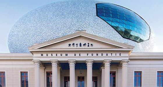 Een grieks aandoende tempel is de voorgevel van museum de Fundatie. Op het dak een grote lichtblauwe eivormige koepel met blauw glazen raam erin.