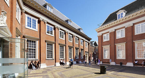 Het plein met het daaraan gelegen elegante bakstenen gebouw van het museum. De ramen zijn groot met kleine ruitjes in witte kozijnen .