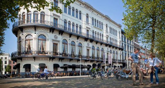 Een foto van de buitenkant van het museum. Een wit sierlijk gebouw van 4 verdiepingen hoog