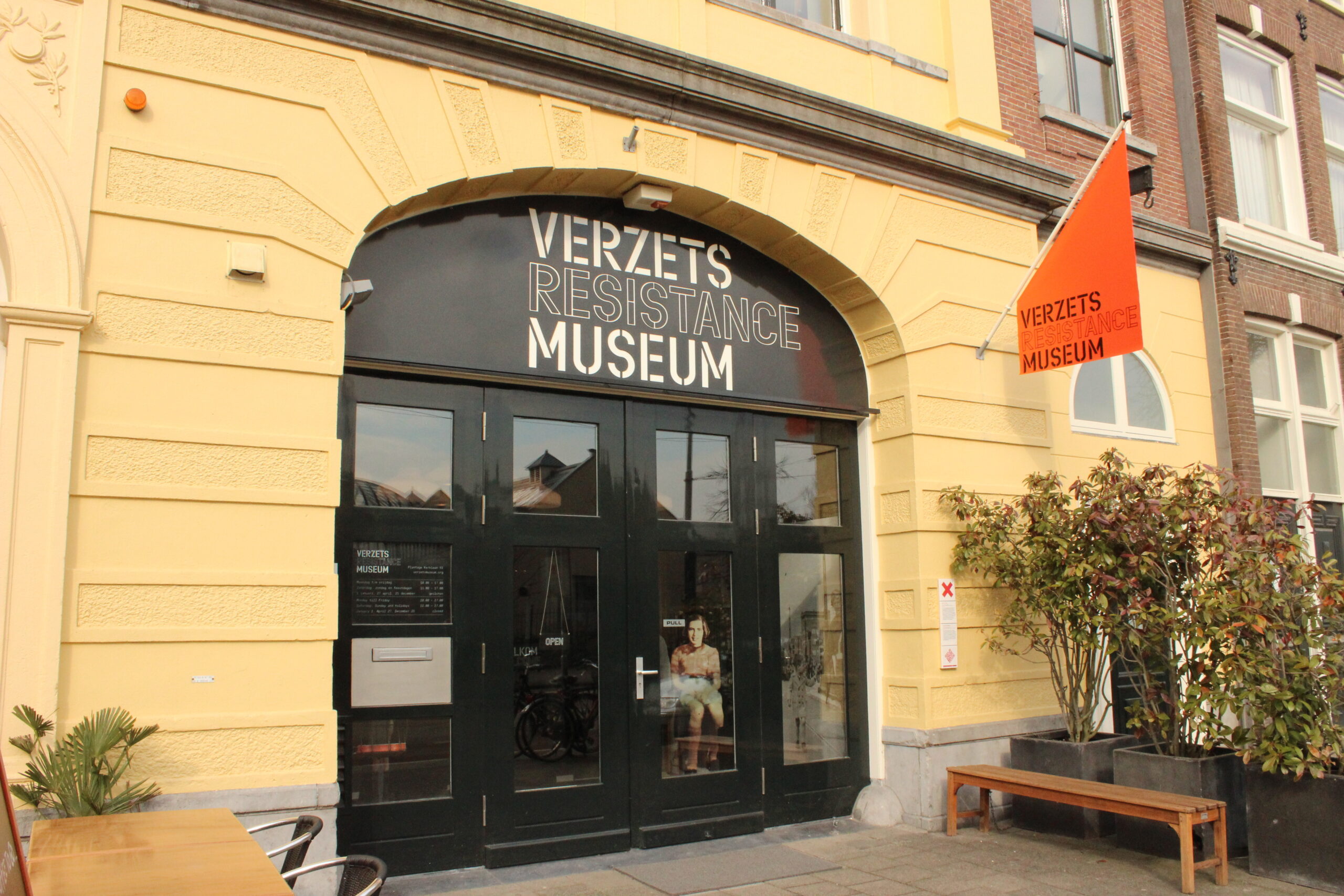 De entree van het museum bevind zich in een gele stenen muur en heeft openslaande glazen deuren. Boven de deur zit een zwarte boog met daarin de tekst verzets resistance museum