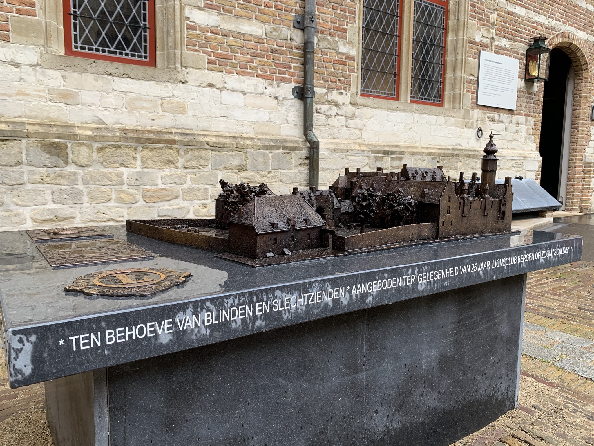 Op een grote stenen tafel staat buiten het gebouw een bronzen maquette van het Markiezenhof. De gebouwen, paleismuren en binnentuin zijn tot in detail uitgevoerd in deze miniatuur versie van het imposante stadspaleis.