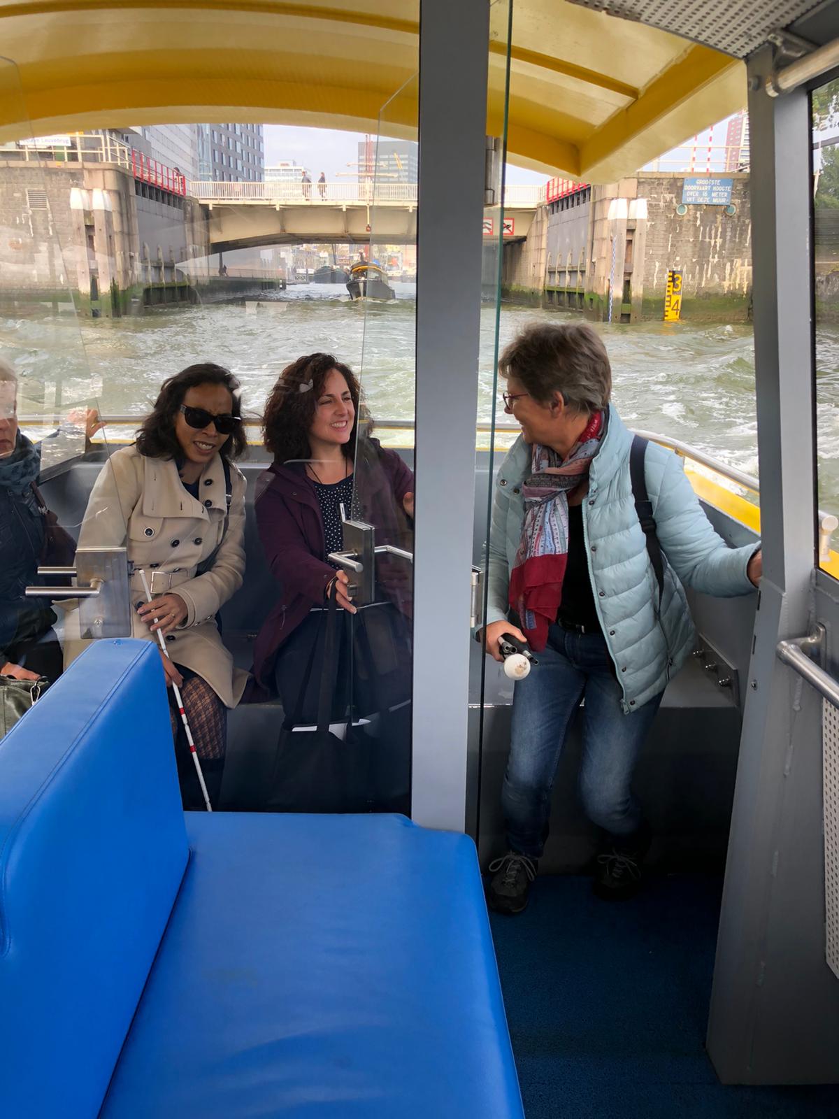 3 dames zittend op het achterdek van de watertaxi met de Leuvenhaven op de achtergrond