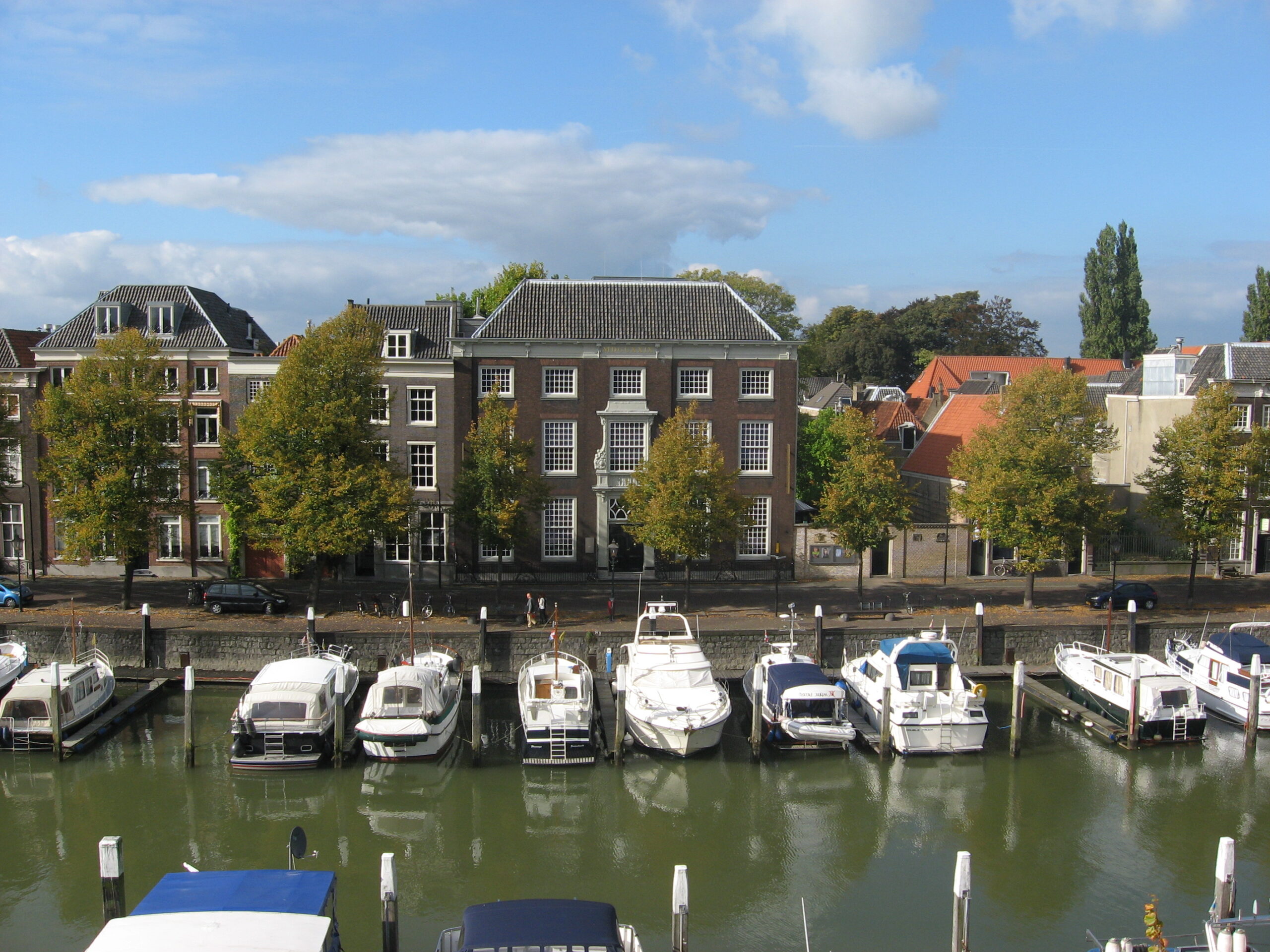 Aan een water waar de boten aan de kade liggen, staat het huis van Gijn. Een statiig gebouw van 3 verdiepingen met volop ramen aan de voorzijde.