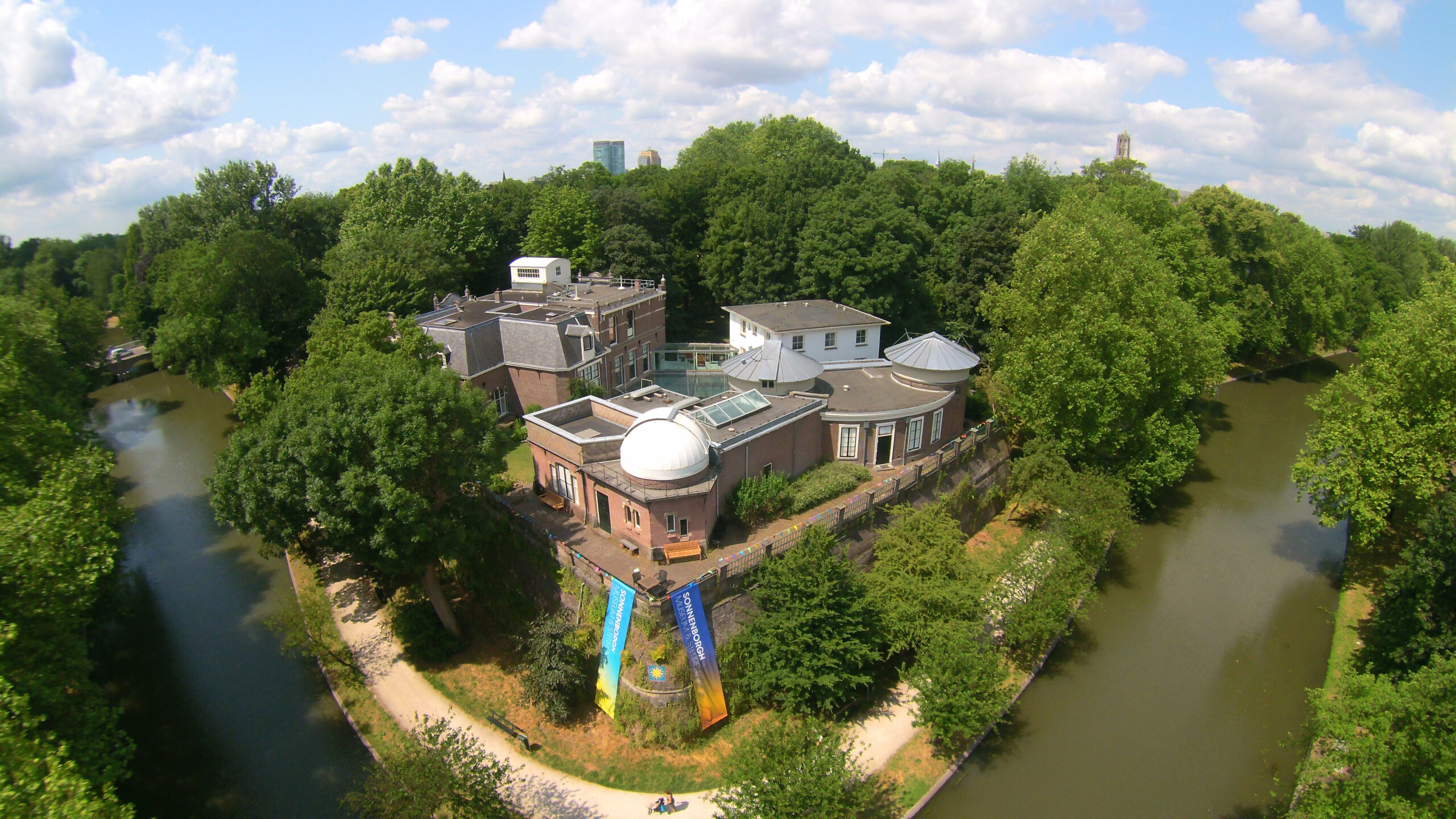 Vanuit de lucht een foto van het gebouw waarin het museum is gevestigd en duidelijk de koepels zichtbaar zijn van waaruit de sterren bekeken kunnen worden.