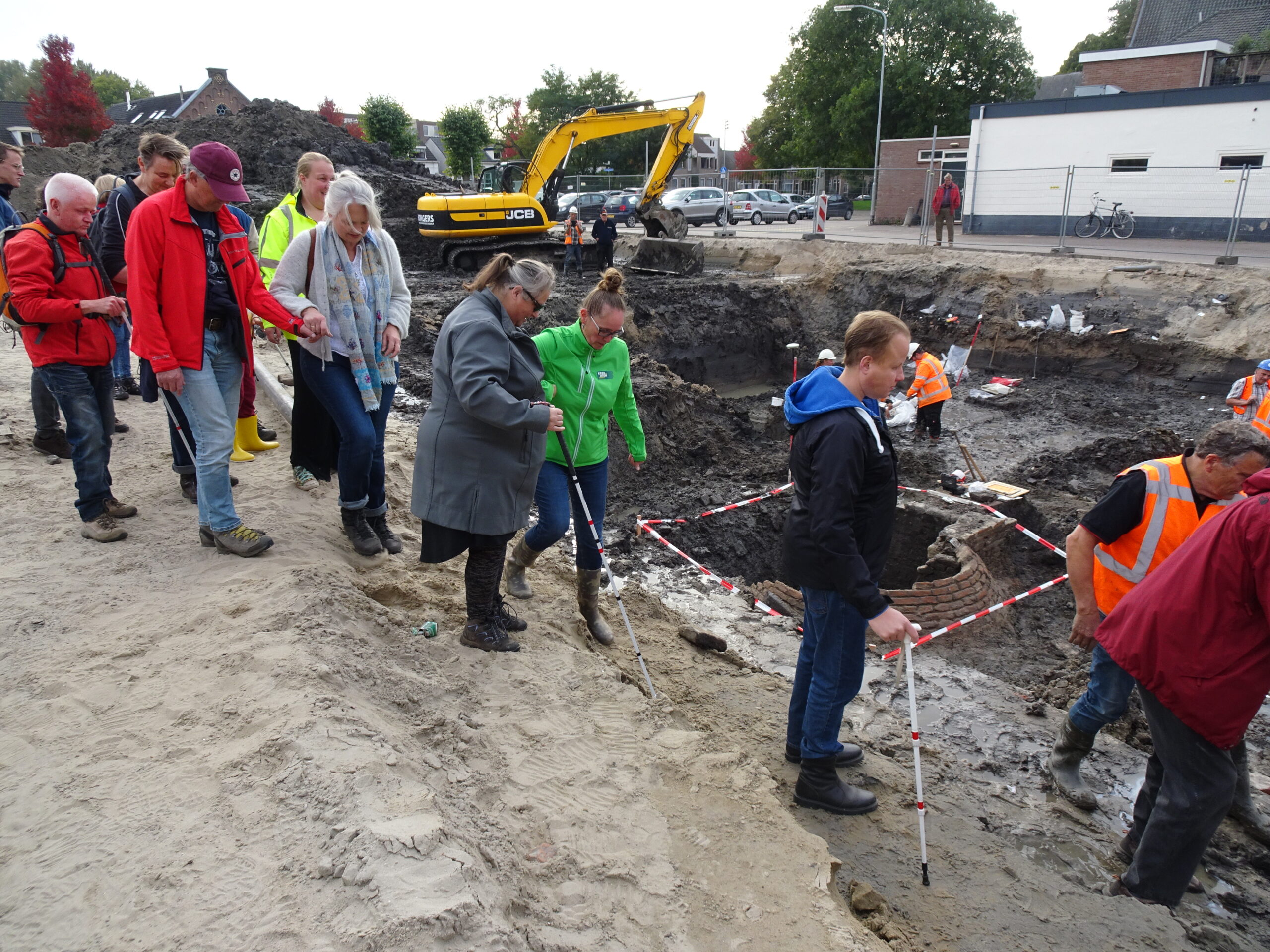 Begeleiders helpen de deelnemers om veilig in de put te stappen